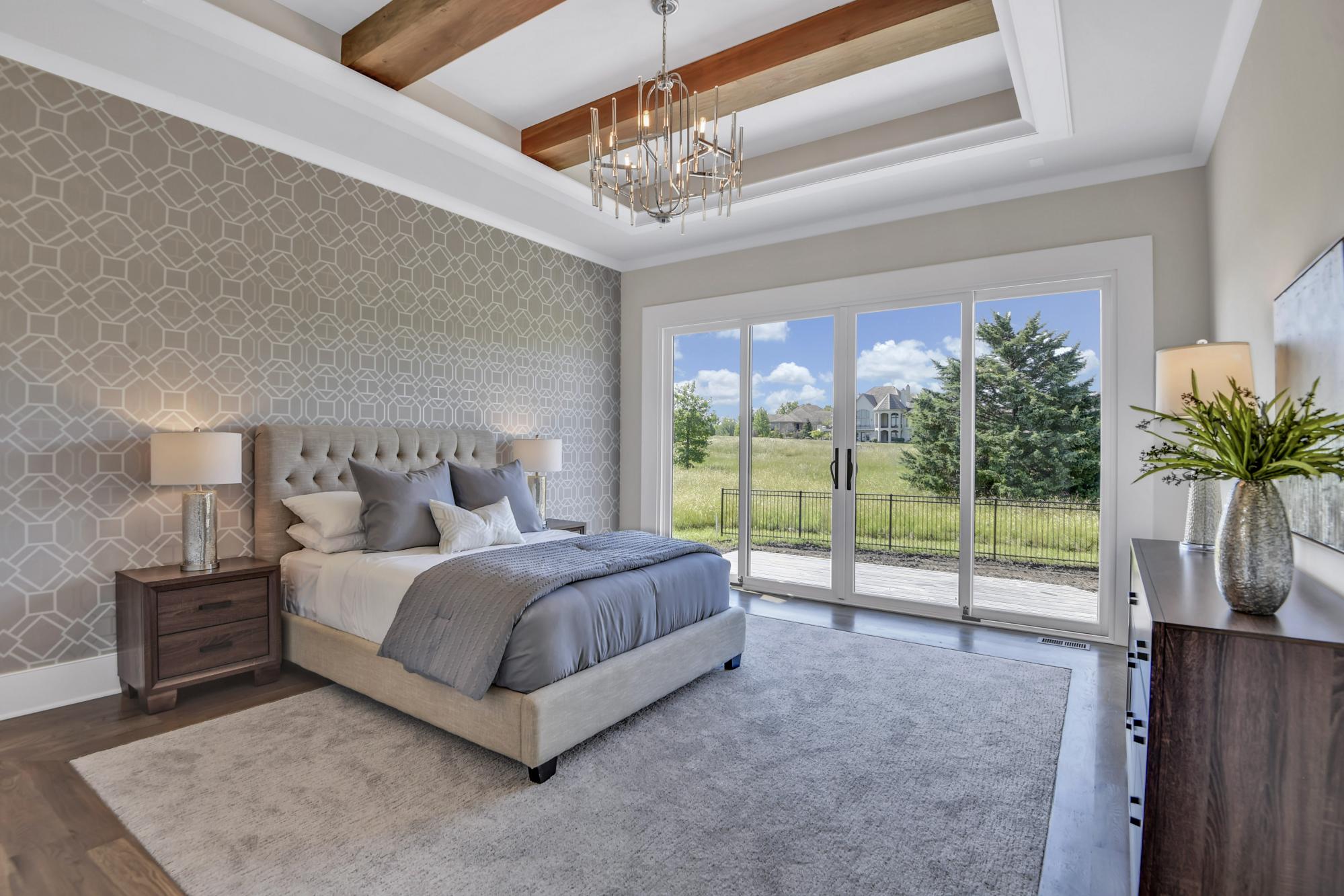 Large bedroom with glass doors leading outside in an Oakmont model from Lambie Custom Homes