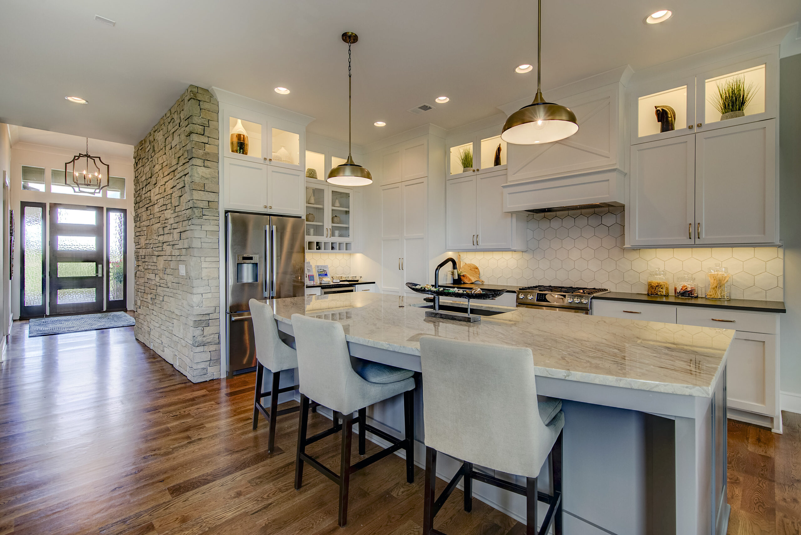 Kitchen with white cabinets and center island in the augusta model from lambie homes