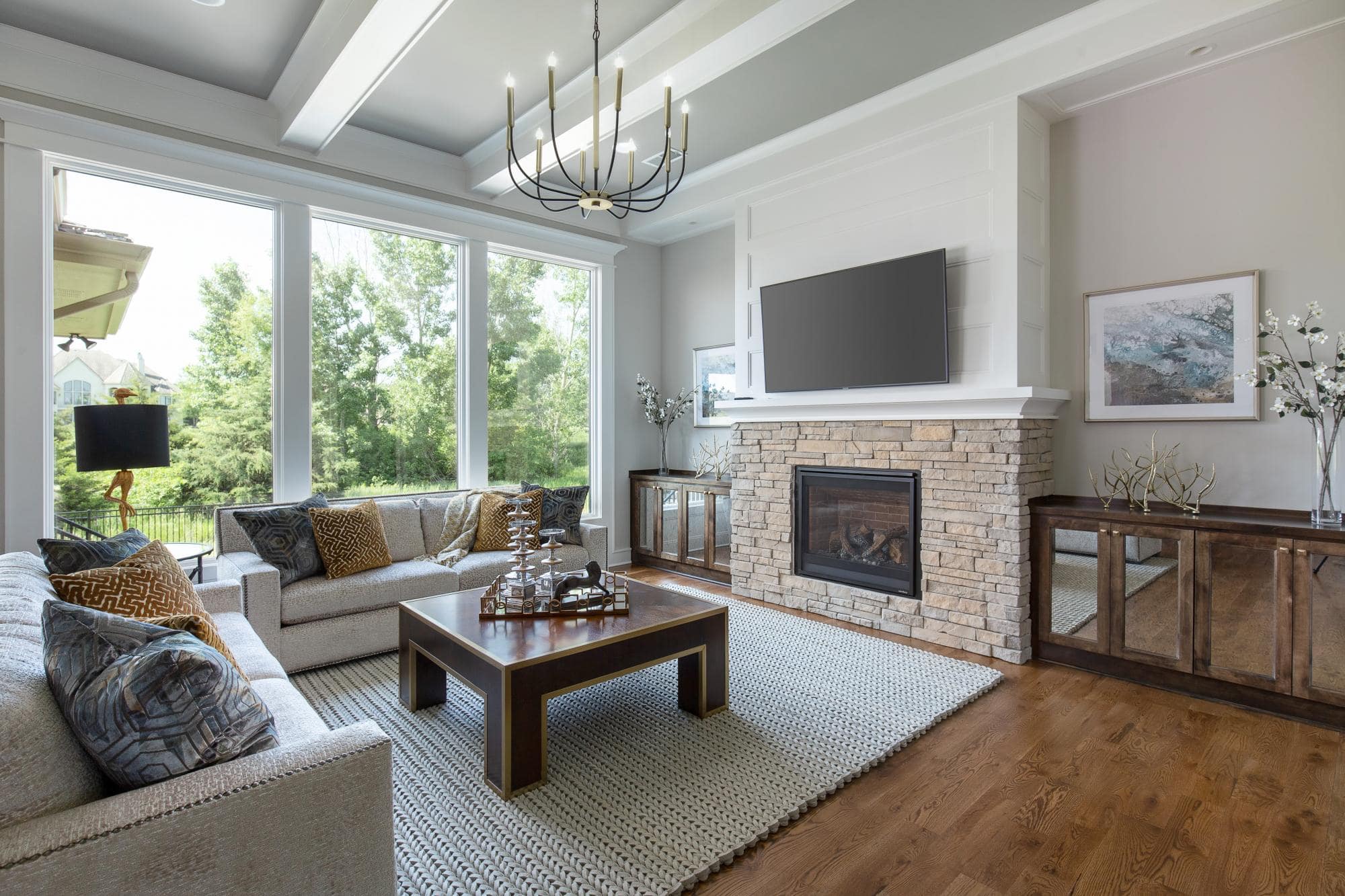 Living room with fireplace and tv above it in a large lambie custom home