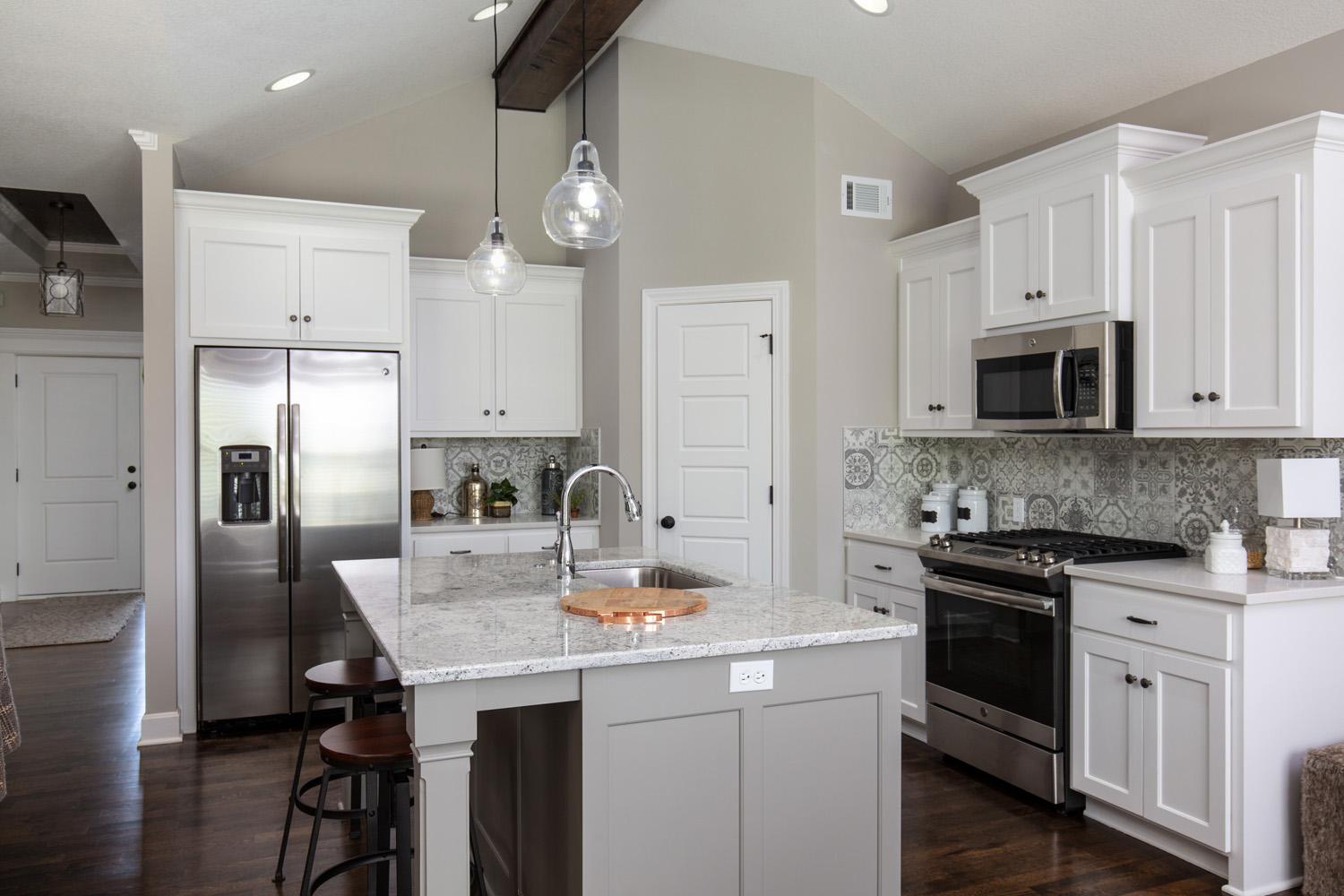 Kitchen with center island and white cabinets in an Ashberry Model from Lambie Custom