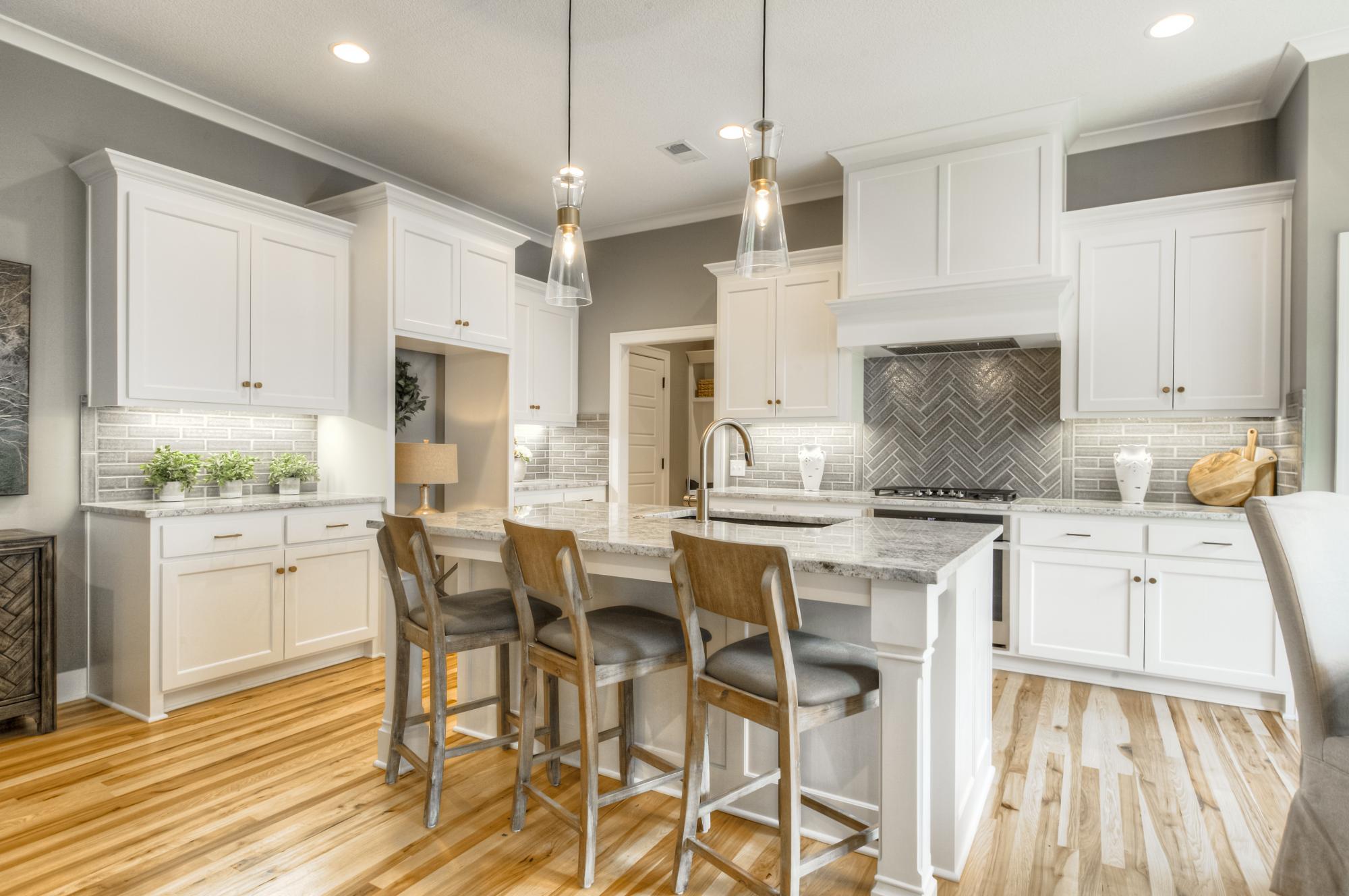 Kitchen with large center island and white cabinets in the Persimmon model from Lambie Custom Homes