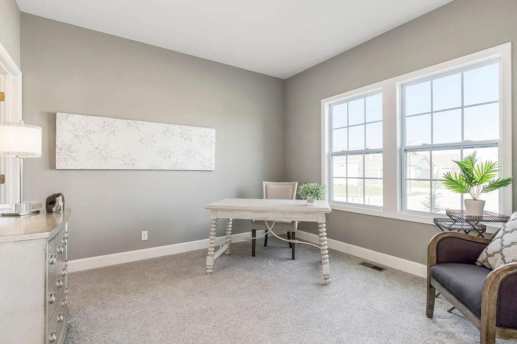 Office with a desk and a dresser in an Enclave at Prairie Star home From Lambie homes