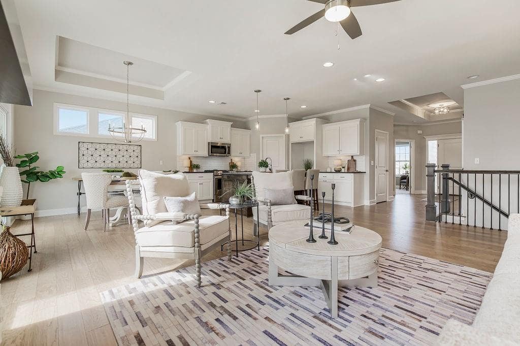 Living area with white furniture in an Enclave at Prairie Star home From Lambie homes