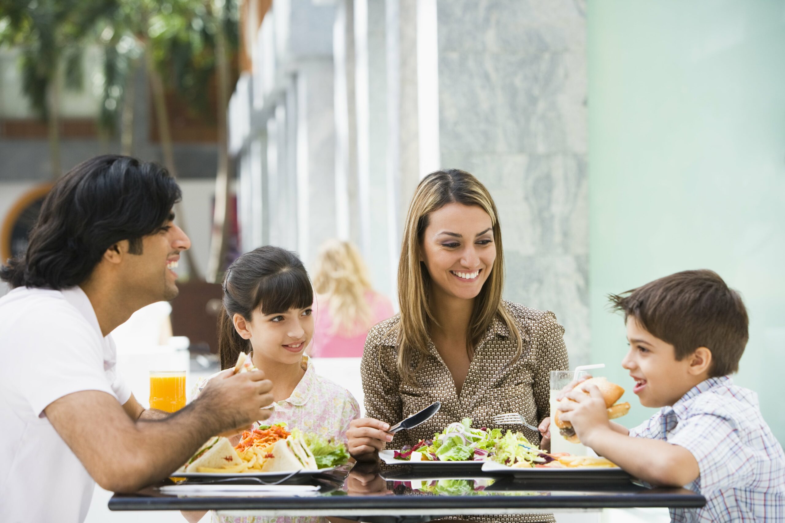 Family with two children enjoying an outdoor lunch at a restaurant